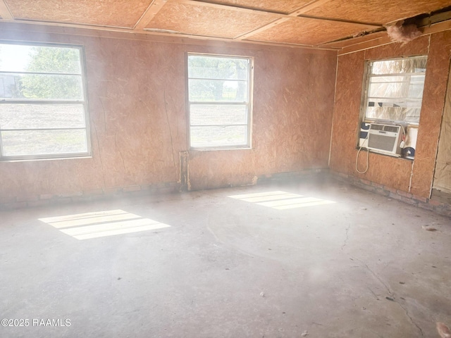 unfurnished room featuring cooling unit and unfinished concrete floors