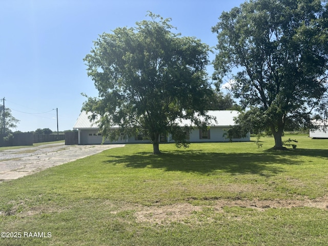 view of yard featuring driveway and a garage