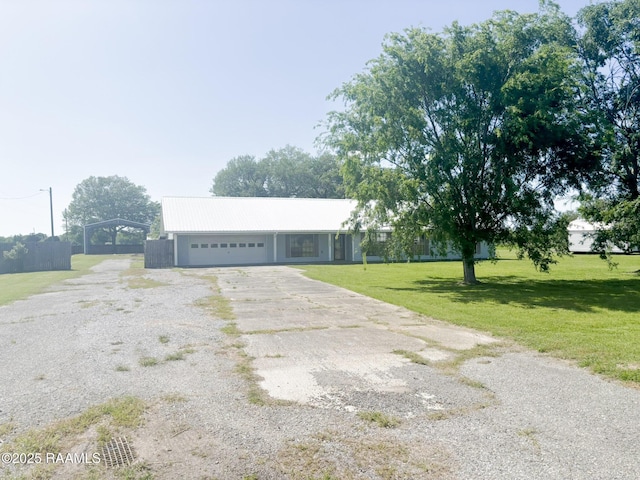 single story home with a garage, a front yard, and driveway