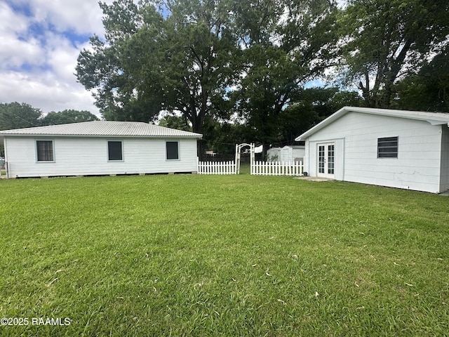 view of yard featuring french doors and fence
