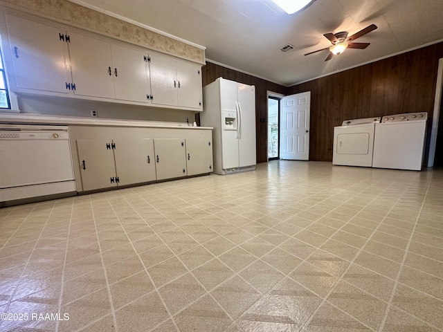 kitchen with wooden walls, light countertops, white appliances, and visible vents