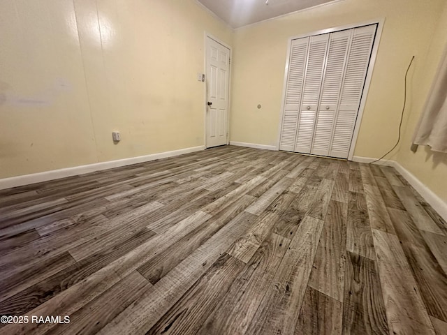 unfurnished bedroom with a closet, baseboards, and wood finished floors