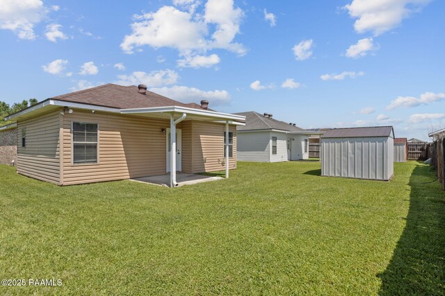 111 Bottle Brush Ln, Carencro, LA 70520 - back of property with an outdoor structure, a shingled roof, a storage shed, a lawn, and a patio
