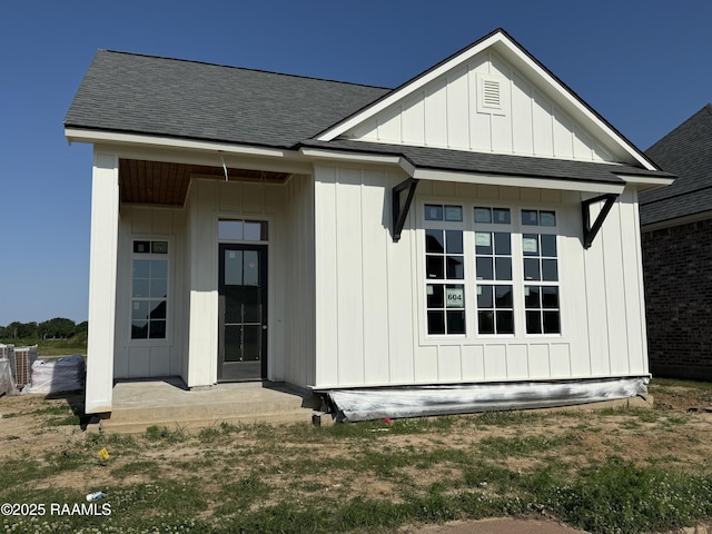 back of property featuring board and batten siding and a shingled roof