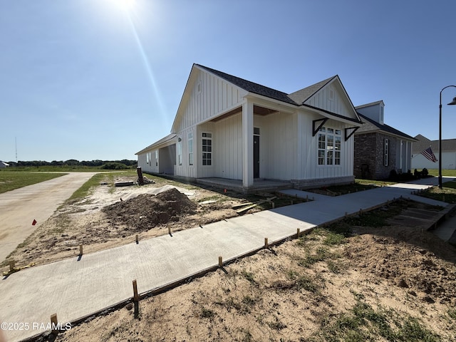 view of front of home with a porch, driveway, and board and batten siding