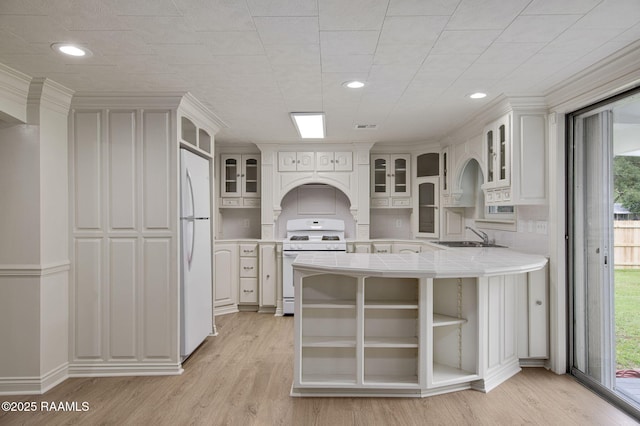 1013 Young St, Broussard, LA 70518 - kitchen with tile counters, a sink, white appliances, light wood-type flooring, and a peninsula