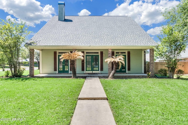 view of front of property with fence, covered porch, french doors, a chimney, and a shingled roof