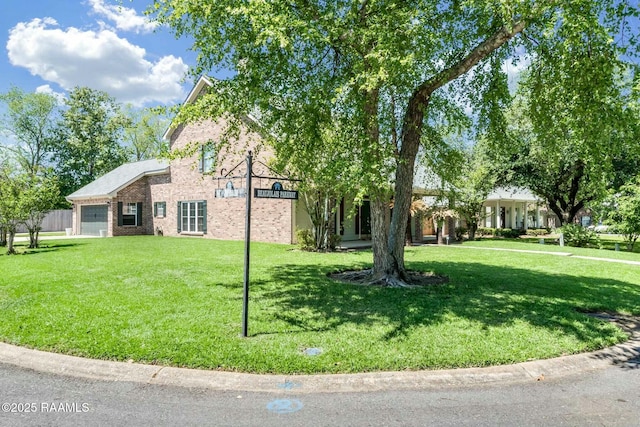 view of front of house featuring brick siding, a garage, and a front lawn