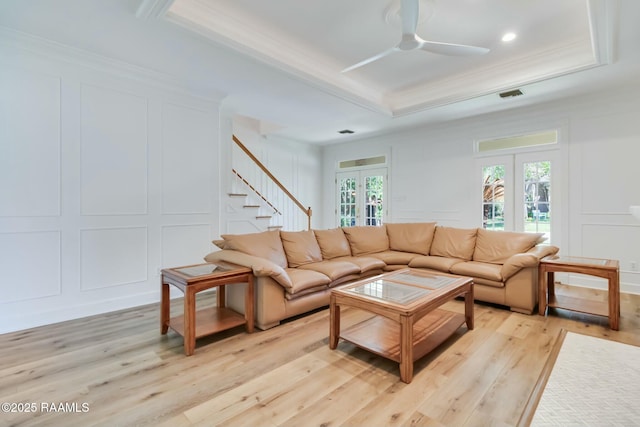 living room with french doors, ornamental molding, a decorative wall, and visible vents
