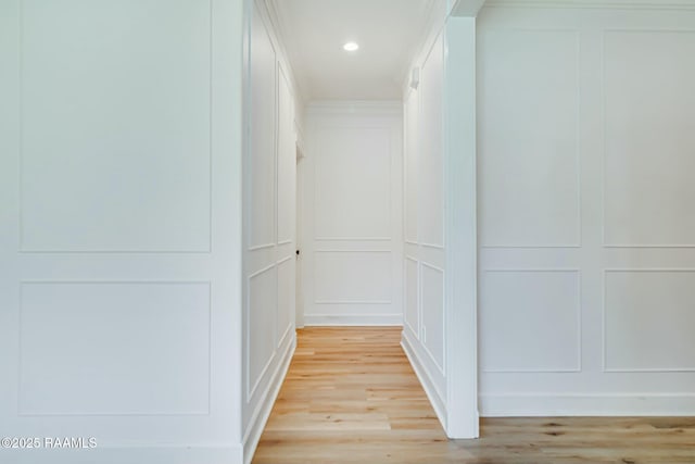 hallway with recessed lighting, light wood-type flooring, and a decorative wall