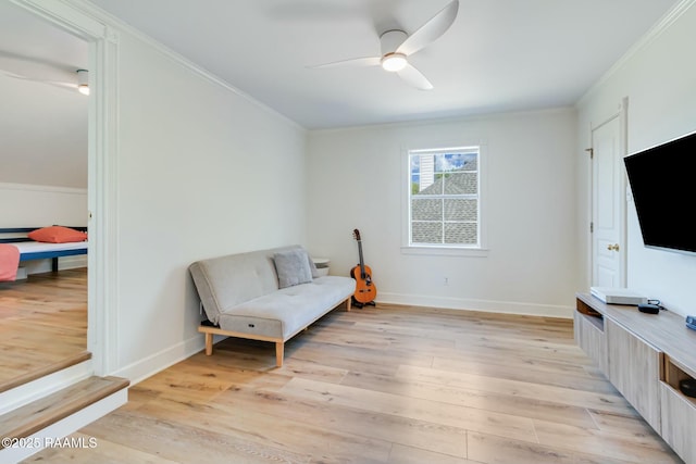 sitting room with baseboards, ceiling fan, ornamental molding, and light wood-style flooring