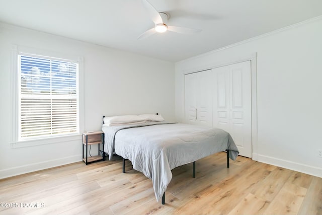 bedroom with a closet, light wood-style floors, ceiling fan, and baseboards
