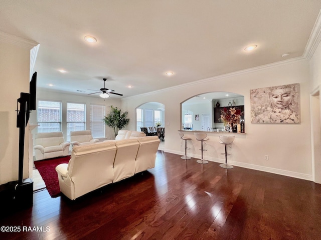 1935 Heberts Pass, Lake Charles, LA 70607 - living room featuring dark wood-style flooring, baseboards, ornamental molding, ceiling fan, and arched walkways