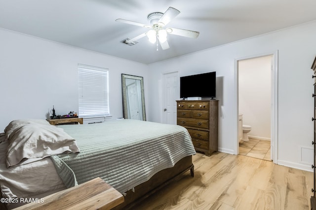 bedroom with light wood-style floors, visible vents, a ceiling fan, and ensuite bathroom
