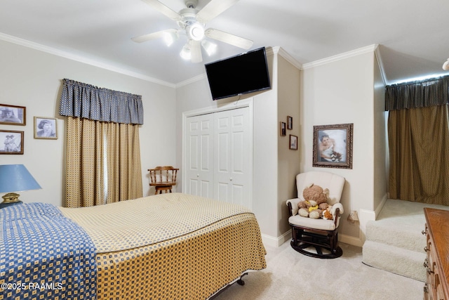 carpeted bedroom featuring ceiling fan, baseboards, crown molding, and a closet