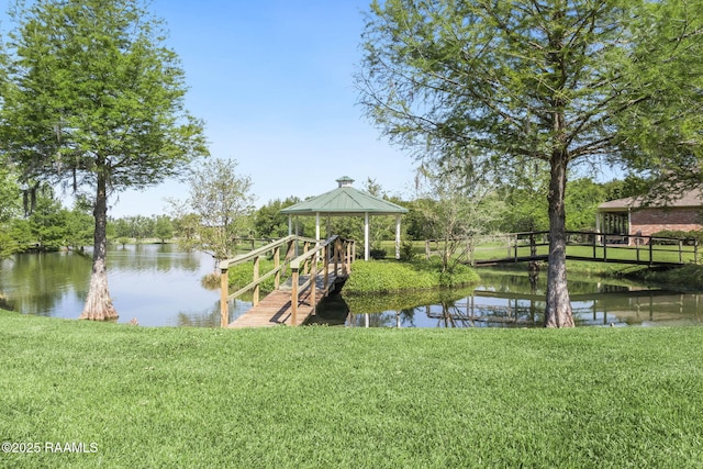 dock area featuring a gazebo, a yard, and a water view