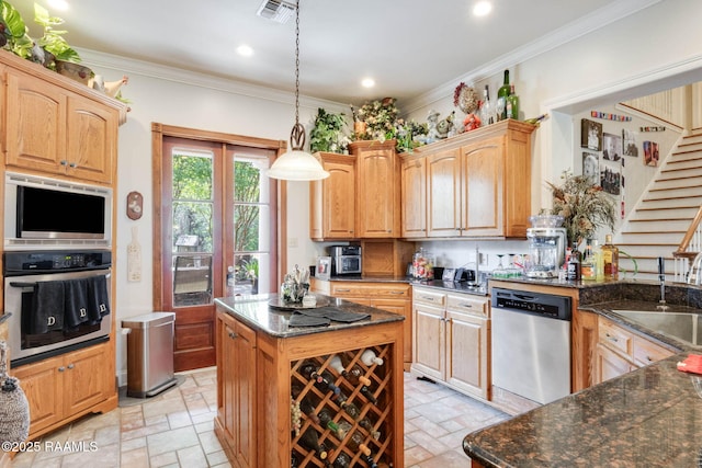 kitchen with a sink, dark stone countertops, visible vents, decorative light fixtures, and appliances with stainless steel finishes