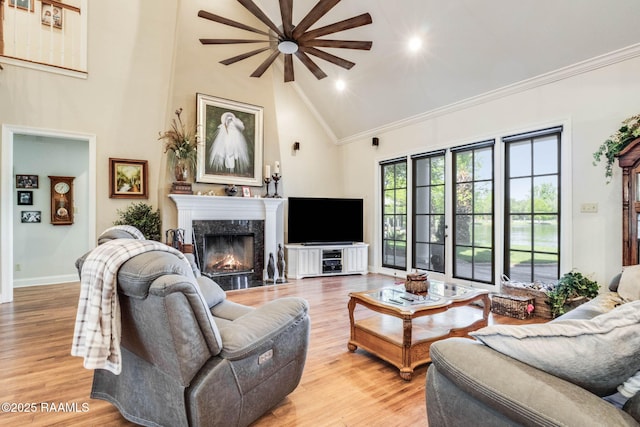 living area with high vaulted ceiling, a ceiling fan, crown molding, and a premium fireplace