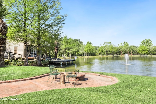 exterior space featuring a fire pit, a water view, and a patio area