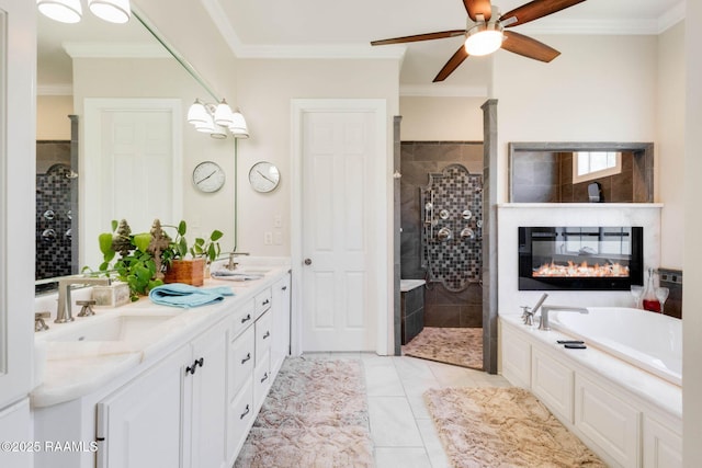 full bath with a ceiling fan, a sink, a glass covered fireplace, a garden tub, and tiled shower