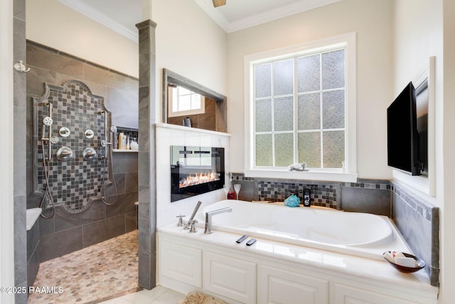bathroom featuring tile patterned floors, walk in shower, a multi sided fireplace, crown molding, and a garden tub