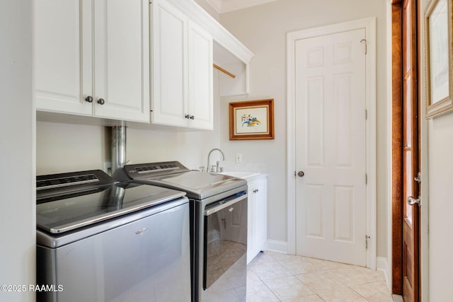 laundry area with a sink, light tile patterned flooring, baseboards, cabinet space, and washer and dryer