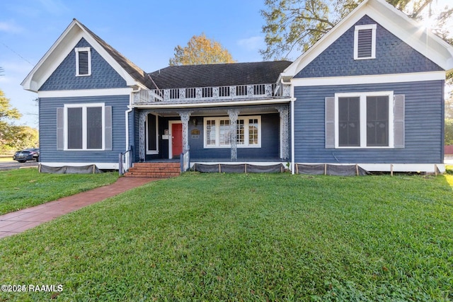 view of front of property featuring a front lawn, roof with shingles, a porch, and a balcony