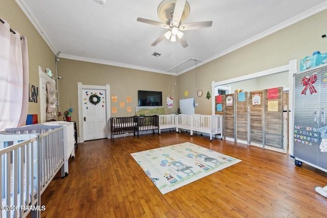 interior space with hardwood / wood-style flooring, ornamental molding, and a ceiling fan
