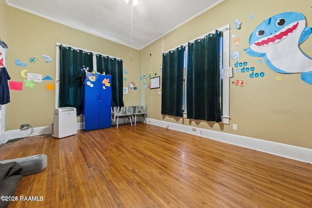 empty room featuring hardwood / wood-style flooring, baseboards, and ornamental molding