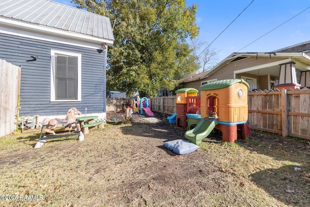 view of yard with a fenced backyard and a playground