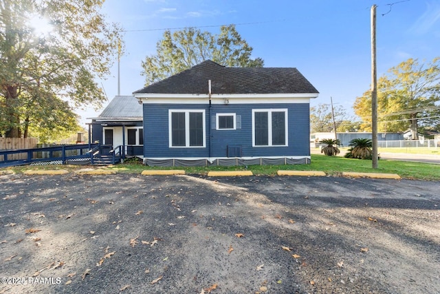 back of property with uncovered parking and fence