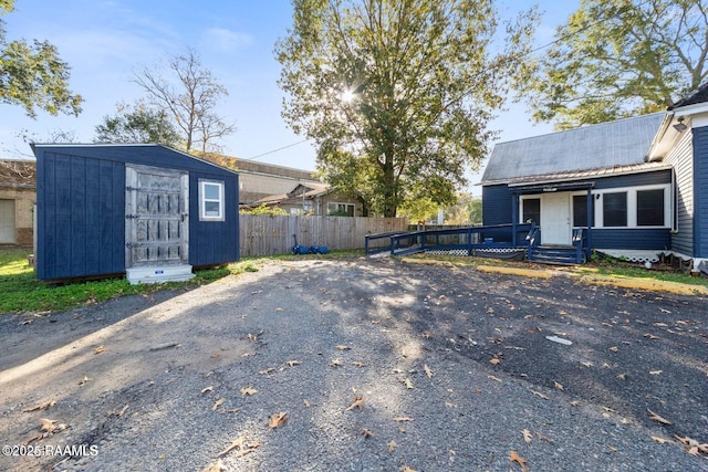 exterior space with a storage unit, an outbuilding, and fence