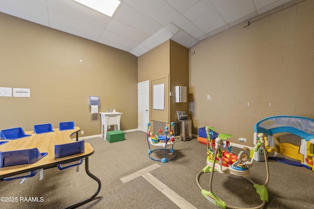 game room with baseboards, a towering ceiling, and carpet floors