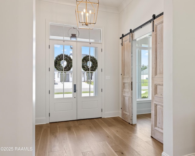 301 Greyford Dr, Lafayette, LA 70503 - foyer featuring french doors, a barn door, baseboards, an inviting chandelier, and hardwood / wood-style floors