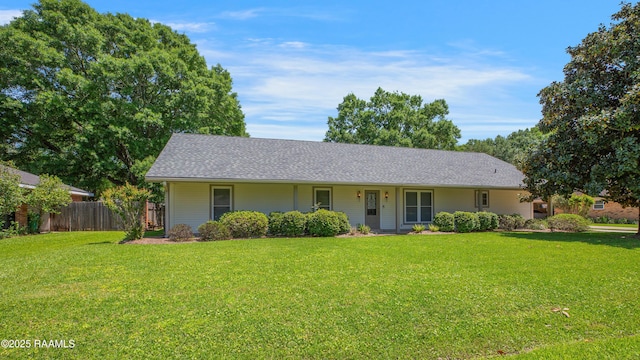 ranch-style home featuring fence, a shingled roof, and a front yard