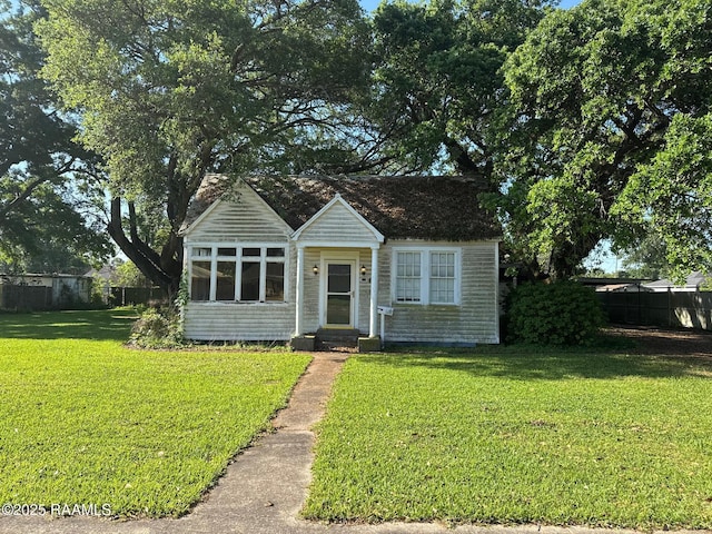 bungalow-style home featuring fence, entry steps, and a front yard