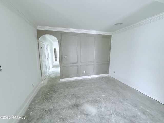 empty room featuring crown molding, arched walkways, concrete floors, and baseboards