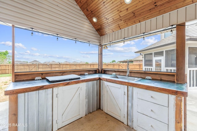 view of patio featuring area for grilling, a sunroom, a fenced backyard, and a sink