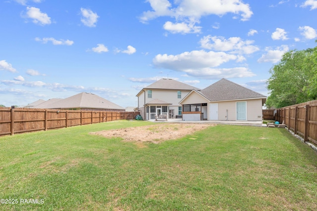 rear view of property with a lawn, a patio area, a fenced backyard, and a sunroom