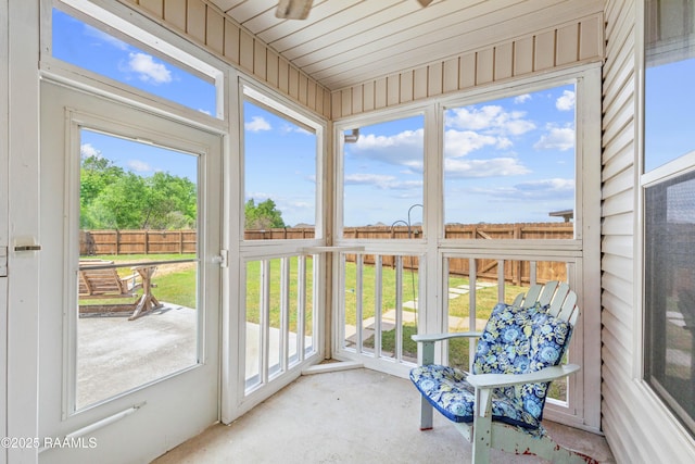 sunroom with a ceiling fan and carpet flooring