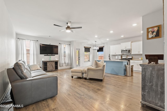 living room featuring recessed lighting, light wood finished floors, a wealth of natural light, and a ceiling fan