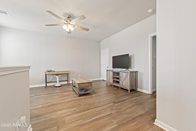 interior space with baseboards, wood finished floors, visible vents, and ceiling fan