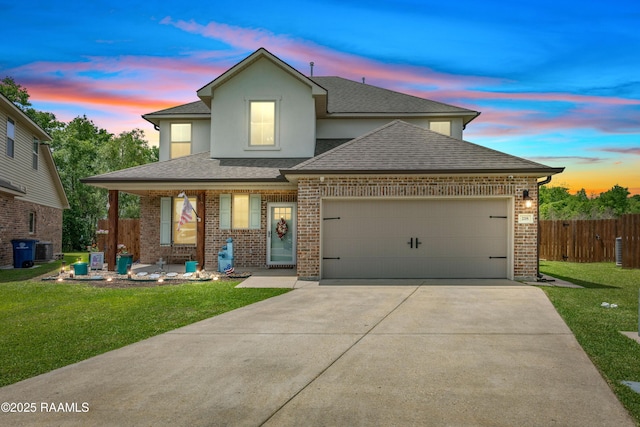 view of front of house with fence, a shingled roof, a front lawn, concrete driveway, and an attached garage
