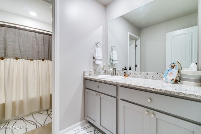 full bath with baseboards and vanity