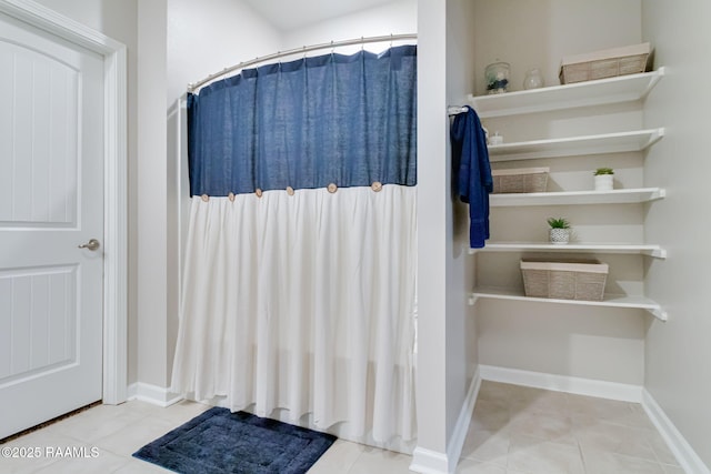 full bath with baseboards, tile patterned floors, and curtained shower