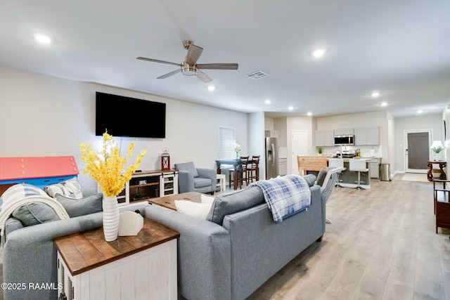 living room with recessed lighting, light wood-type flooring, visible vents, and a ceiling fan