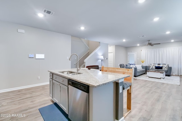 kitchen featuring light wood-type flooring, stainless steel dishwasher, visible vents, and a sink