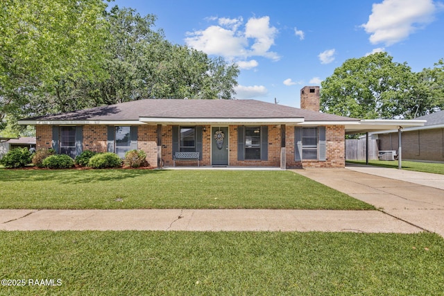 single story home featuring brick siding, an attached carport, a front yard, a chimney, and concrete driveway