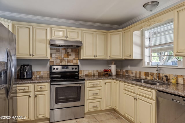 kitchen featuring cream cabinets, crown molding, a sink, stainless steel appliances, and under cabinet range hood
