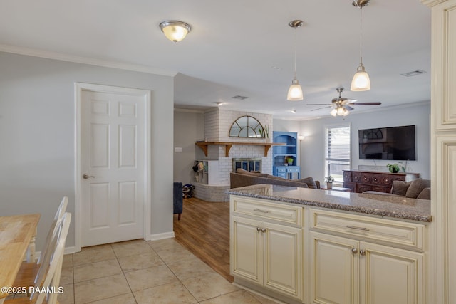 kitchen with crown molding, ceiling fan, and cream cabinetry